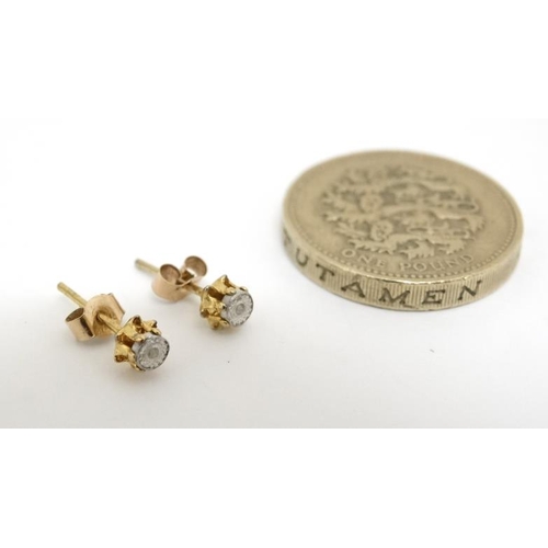 1082 - A pair of gilt metal stud earrings set with illusion set white stones.