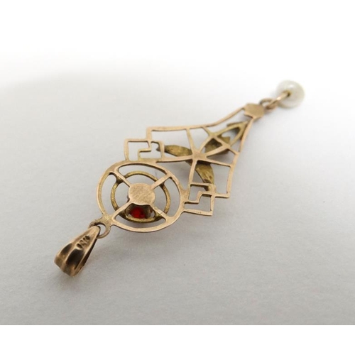 1083 - A yellow metal pendant with open work decoration red stone and pearl drop. Approx 1'' long