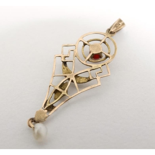 1083 - A yellow metal pendant with open work decoration red stone and pearl drop. Approx 1'' long