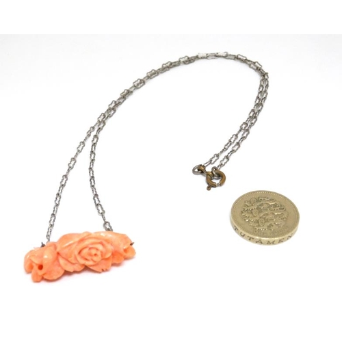 1088 - A white metal chain set with carved coral? Pendant of floral form. Approx 20'' long