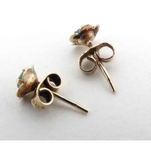 1089 - A pair of yellow metal stud earrings set with emeralds