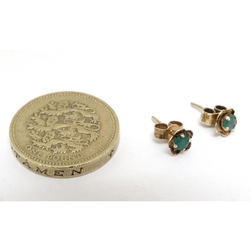 1089 - A pair of yellow metal stud earrings set with emeralds