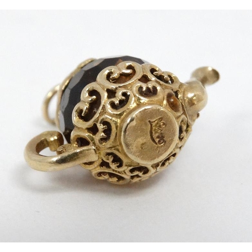 1091 - A pendant / charm formed as a miniature teapot the facet amber coloured body with yellow metal mount... 