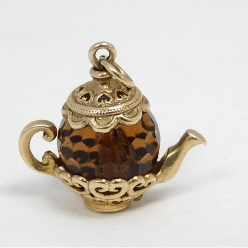 1091 - A pendant / charm formed as a miniature teapot the facet amber coloured body with yellow metal mount... 