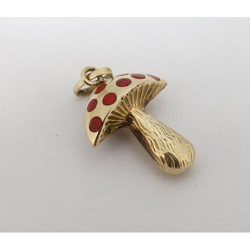 1092 - A 14ct (585) gold pendant / charm formed as a toadstool with red enamel decoration. Approx ¾'' high