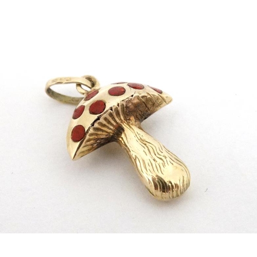 1092 - A 14ct (585) gold pendant / charm formed as a toadstool with red enamel decoration. Approx ¾'' high