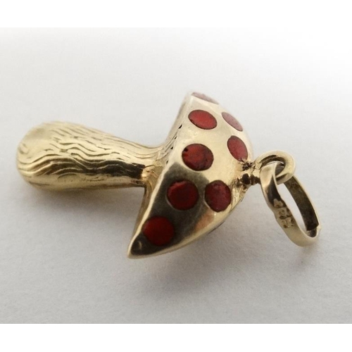 1092 - A 14ct (585) gold pendant / charm formed as a toadstool with red enamel decoration. Approx ¾'' high