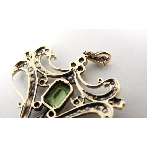 1093 - A 9ct gold pendant set with central peridot and a profusion of seed pearls 1 ¾'' high