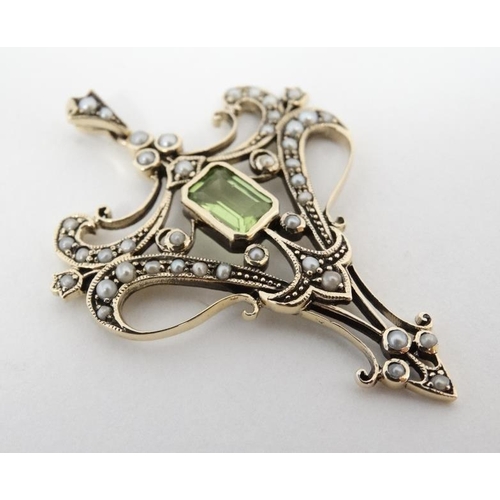 1093 - A 9ct gold pendant set with central peridot and a profusion of seed pearls 1 ¾'' high