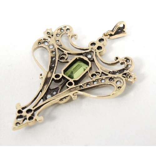 1093 - A 9ct gold pendant set with central peridot and a profusion of seed pearls 1 ¾'' high