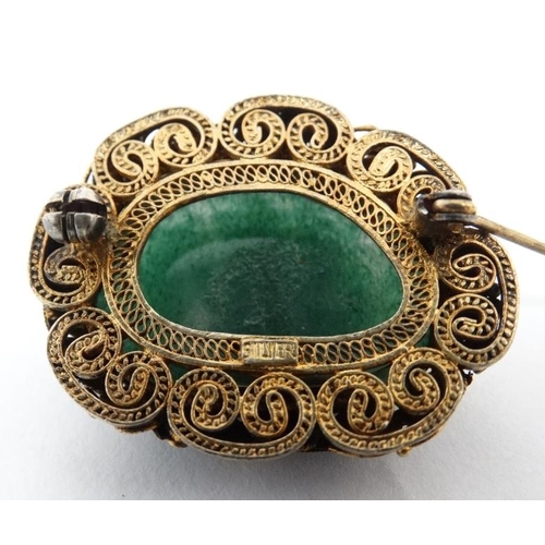 1100 - A late 20thC Oriental brooch with central jade like stone in a gilt metal mount with enamel decorati... 