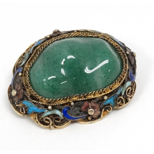 1100 - A late 20thC Oriental brooch with central jade like stone in a gilt metal mount with enamel decorati... 