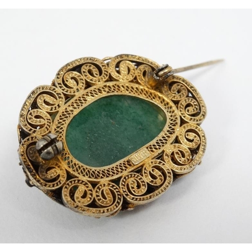 1100 - A late 20thC Oriental brooch with central jade like stone in a gilt metal mount with enamel decorati... 