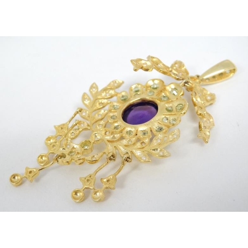 1102 - A silver gilt pendant set with amethyst cabochon to centre and a profusion of peridot and seed pearl... 