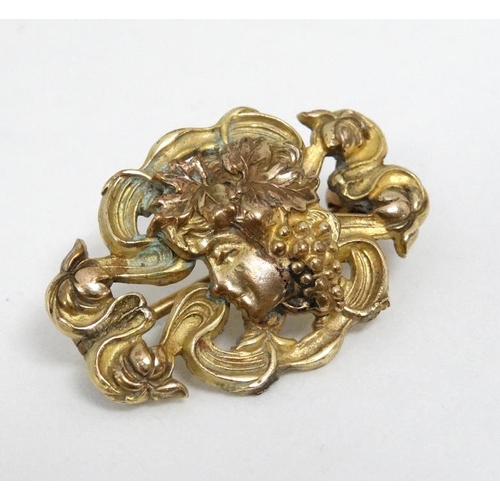 1106 - A gilt metal Art Nouveau brooch with female head to centre. 1 1/8'' wide