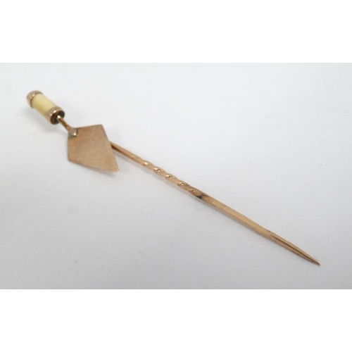 1118 - A 9ct gold stick pin surmounted by a 9ct gold miniature trowel.  The whole 2 ½'' long