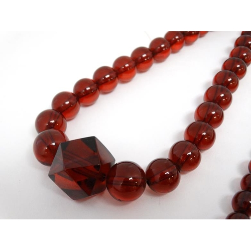 1122 - 2 Vintage necklaces of graduated cherry amber coloured beads. 20'' long and 17'' long