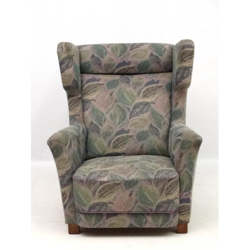 142 - Vintage Retro : A Danish upholstered wing back  armchair with show wood feet, 38 1/2'' high