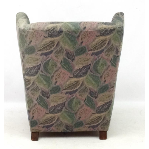 142 - Vintage Retro : A Danish upholstered wing back  armchair with show wood feet, 38 1/2'' high