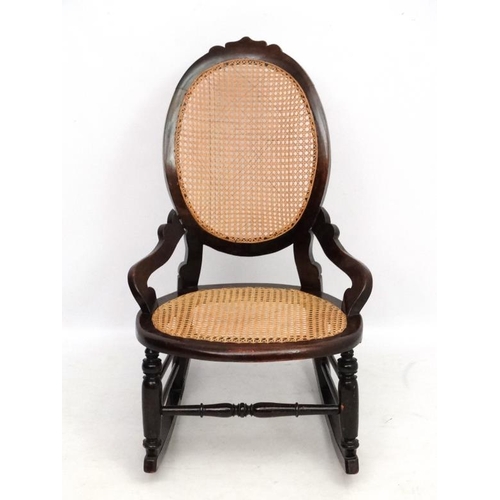 212 - A Victorian cane  rocking chair with oval cameo shaped back. 35'' high