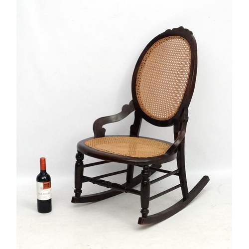 212 - A Victorian cane  rocking chair with oval cameo shaped back. 35'' high