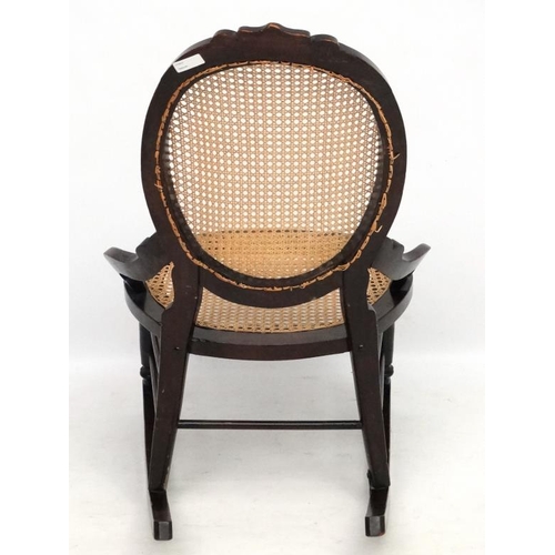 212 - A Victorian cane  rocking chair with oval cameo shaped back. 35'' high