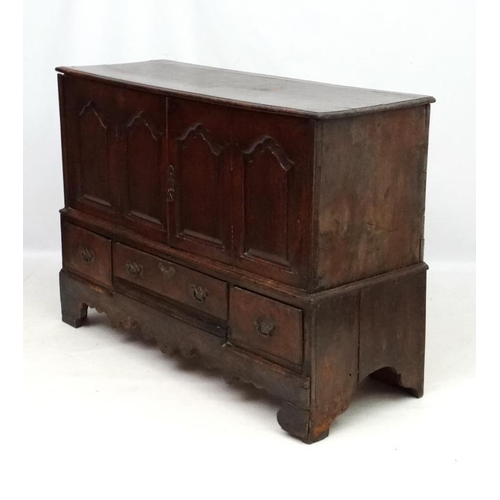 217 - An early 18thC oak four panelled mule chest with 3 drawers under ( the central 2 panels now opening ... 