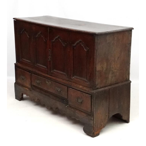 217 - An early 18thC oak four panelled mule chest with 3 drawers under ( the central 2 panels now opening ... 