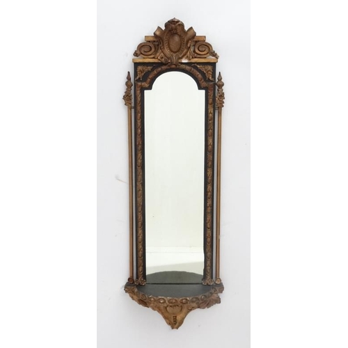 230 - A 19thC French hall mirror in the pier style with gilt and black decoration. 35'' high x 11 1/2'' wi... 