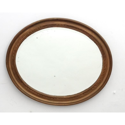 231 - A c.1900 oval bevelled edged wall mirror, the whole 23'' wide x 20'' deep