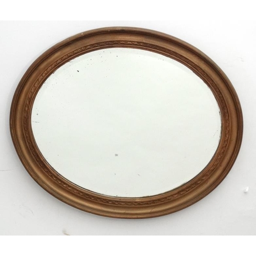 231 - A c.1900 oval bevelled edged wall mirror, the whole 23'' wide x 20'' deep