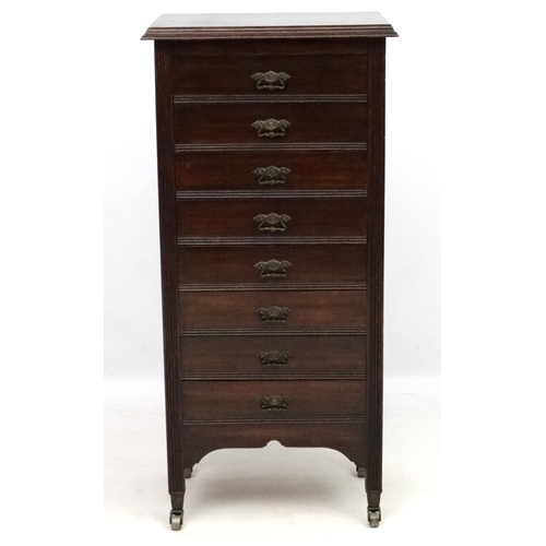 282 - Music cabinet : A c.1900 stained oak tall narrow chest of 8 drawers. The whole 21'' wide x 14 1/3'' ... 