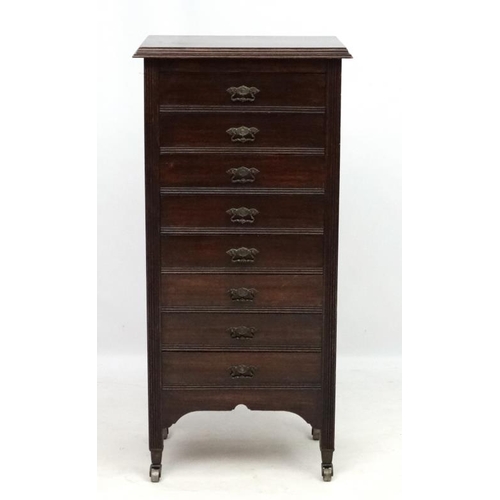 282 - Music cabinet : A c.1900 stained oak tall narrow chest of 8 drawers. The whole 21'' wide x 14 1/3'' ... 