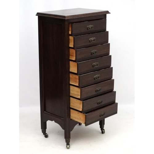 282 - Music cabinet : A c.1900 stained oak tall narrow chest of 8 drawers. The whole 21'' wide x 14 1/3'' ... 