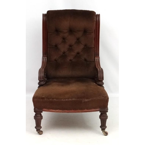 310 - A late 19thC mahogany elbow chair with button back upholstery and fluted and turned front legs. 37''... 