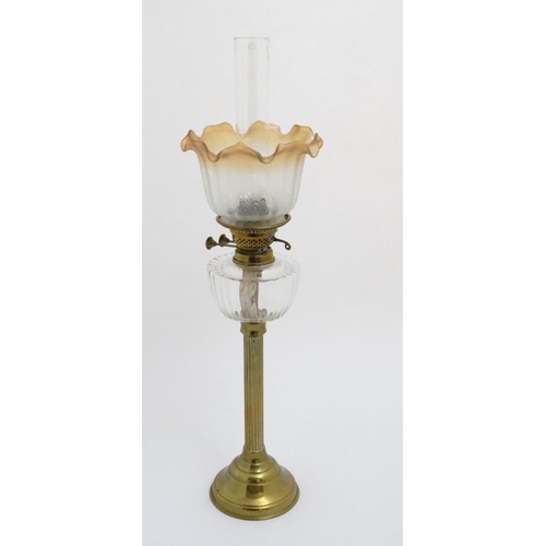 320 - Oil lamp : a c 1900 brass and glass oil lamp with circular reeded column, circular base , clear glas... 