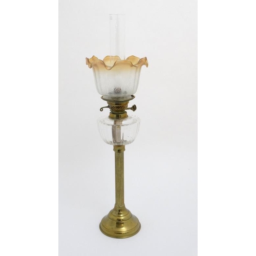 320 - Oil lamp : a c 1900 brass and glass oil lamp with circular reeded column, circular base , clear glas... 