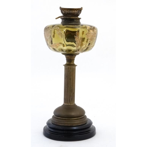 322 - An unusual oil lamp with reeded column, circular base and gilt with tube lined enamel amber coloured... 