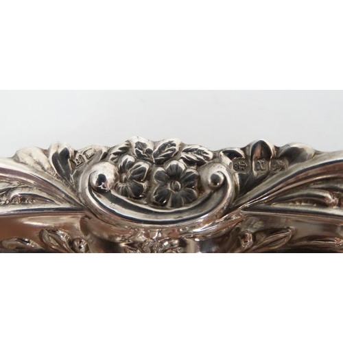 533 - A matched pair of silver dishes with embossed floral and scroll decoration. Hallmarked Birmingham 18... 