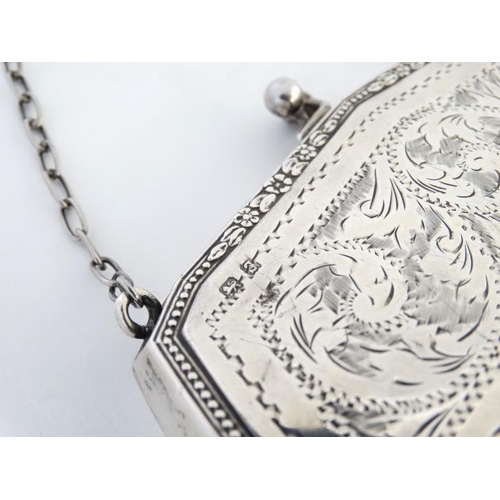 534 - A silver purse with engraved decoration and calf skin lined interior, hallmarked Birmingham 1917 mak... 