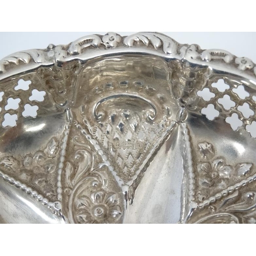 558 - A silver bon bon dish of circular form with embossed and pierced decoration on 3 ball feet hallmarke... 