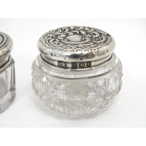 575 - 2 cut glass dressing table pots with silver lids. Hallmarked Birmingham 1917 maker G& C Ltd and Birm... 