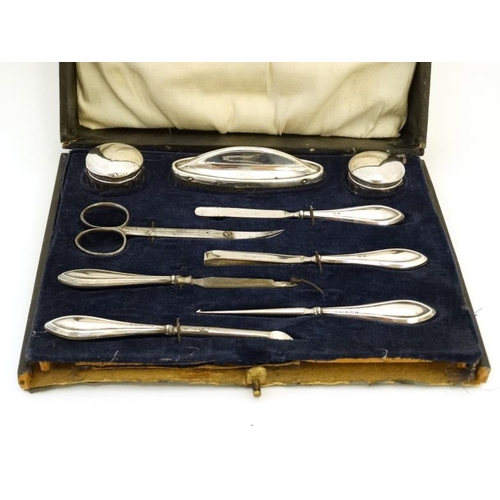 590 - A silver mounted manicure set comprising files, tweezers, pots, nail buffer etc. Birmingham 1916 mak... 