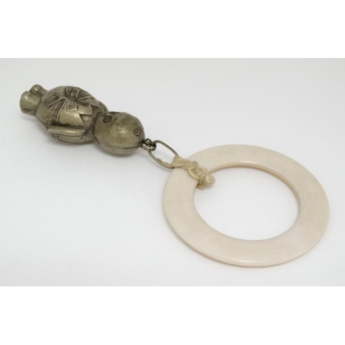 598 - A silver plate rattle formed as a stylized Kewpie doll with ivorine teether ring.