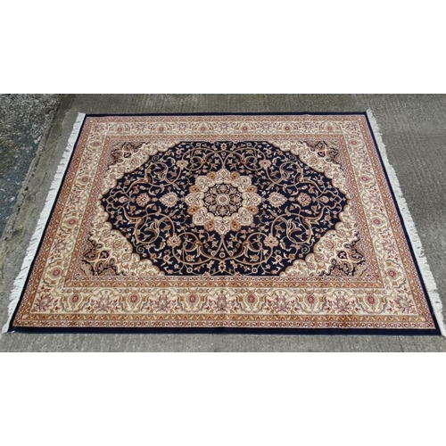 60 - Carpet / Rug:    A machine made Persian Keshan style carpet with midnight blue / black central groun... 