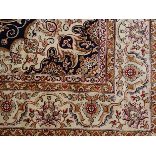 60 - Carpet / Rug:    A machine made Persian Keshan style carpet with midnight blue / black central groun... 