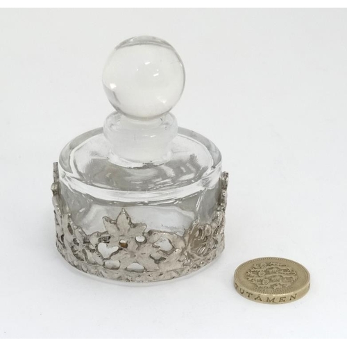 604 - A glass scent bottle with applied white metal decoration. Approx 2 1/2'' high