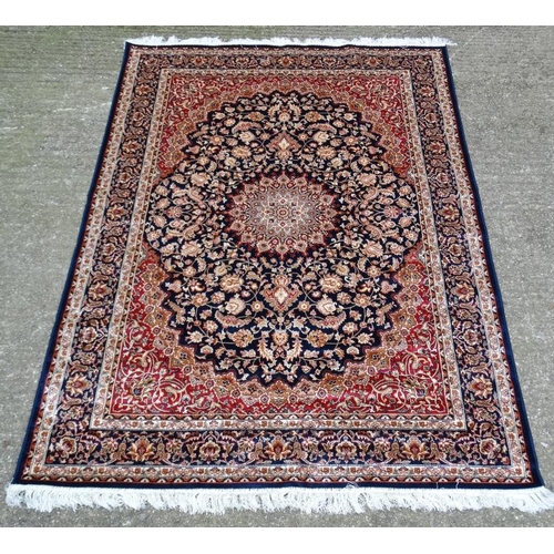 63 - Carpet / Rug : A machine made Keshan carpet, the blue and red ground with stylised floral motiffs. 6... 