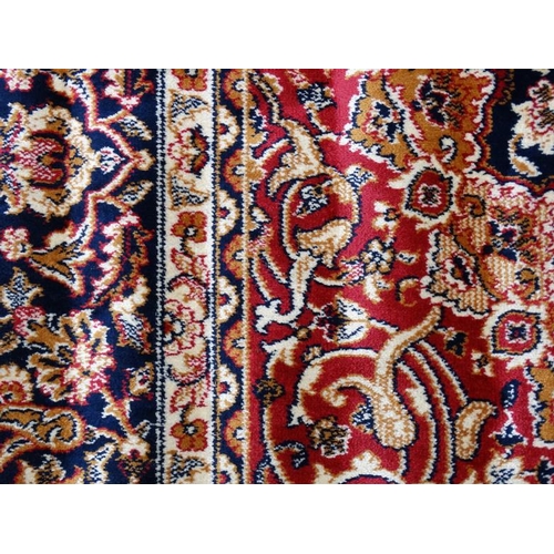 63 - Carpet / Rug : A machine made Keshan carpet, the blue and red ground with stylised floral motiffs. 6... 