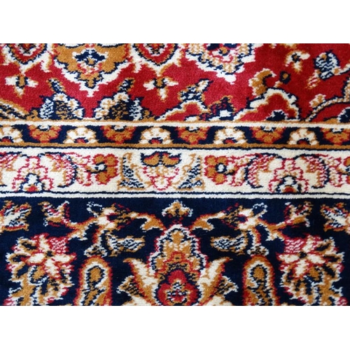 63 - Carpet / Rug : A machine made Keshan carpet, the blue and red ground with stylised floral motiffs. 6... 